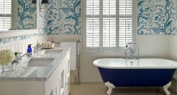 Elegantná provencia kúpeľňa s modrou voľne stojacou vaňou, dvojumývadlom a tapetou s modrobielym prírodným motívom