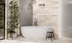 Biela voľne stojaca vaňa pri stene v drevodekore, geometrické závesné svetlá, čierna sprchová batéria a stolička s uteráky