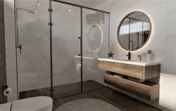 Kúpeľňa s veľkým skleneným sprchovacím kútom v čiernom ráme, drevenou závesnou skrinkou a okrúhlym LED zrkadlom nad zapusteným umývadlom