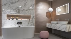 Luxusná kúpeľňa s voľne stojacou vaňou, dvojitým umývadlom a mramorovým obkladom; ambientné osvetlenie a dizajnové závesné lampy