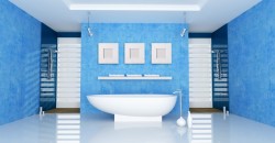 Minimalistická kúpeľňa v modrých tónoch s voľne stojacou oválnou vaňou uprostred a dvoma sprchovými kútmi