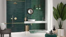 Luxusná kúpeľňa s tmavo zelenými obkladmi, bielym závesným pultom s umývadlom, zlatými doplnkami a zelenými závesnými svetlami