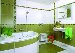 Kúpeľňa s rohovou vaňou, zelenými obkladmi a zvislými kvetinovými pásmi, závesným WC a umývadlom so zrkadlovou skrinkou
