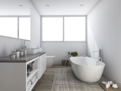 Moderná biela kúpeľňa s voľne stojacou vaňou, obdĺžnikovým umývadlom na mramorovej doske; kubistické kúpeľňové doplnky