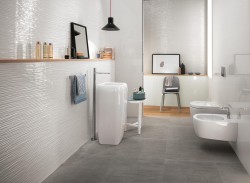 Moderná kúpeľňa so šedou dlažbou, vysokým umývadlom, závesným WC a bidetom; drevená polica a čierne závesné svetlo