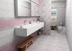 Úzka kúpeľňa s dlhým žľabovým umývadlom, ružovým obkladom, patchworkovým dekorom a WC s bidetom
