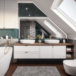 Podkrovná kúpeľňa s dvoma umývadlami na drevenej doske, oválnou vaňou, zeleným obkladom pod šikminou a zlatými batériami